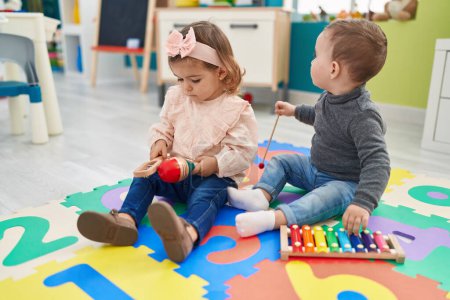 Photo for Adorable boy and girl playing xylophone and maraca at kindergarten - Royalty Free Image