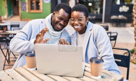 Téléchargez les photos : Homme et femme couple ayant appel vidéo assis sur la table à café terrasse - en image libre de droit
