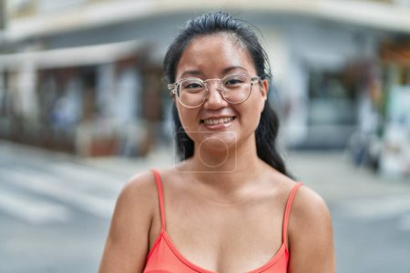 Foto de Young chinese woman smiling confident standing at street - Imagen libre de derechos