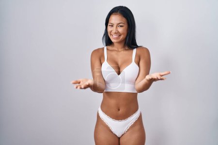 Photo for Hispanic woman wearing lingerie smiling cheerful offering hands giving assistance and acceptance. - Royalty Free Image