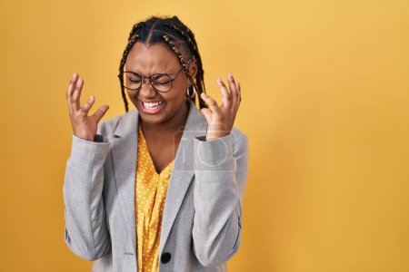 Téléchargez les photos : Femme afro-américaine avec des tresses debout sur fond jaune célébrant fou et fou de succès avec les bras levés et les yeux fermés hurlant excité. concept gagnant - en image libre de droit