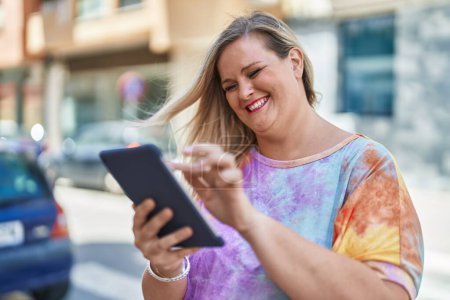 Téléchargez les photos : Jeune femme souriant confiant en utilisant touchpad à la rue - en image libre de droit