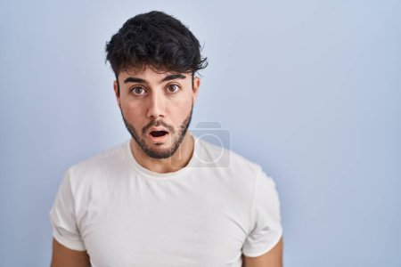 Téléchargez les photos : Hispanic man with beard standing over white background afraid and shocked with surprise and amazed expression, fear and excited face. - en image libre de droit