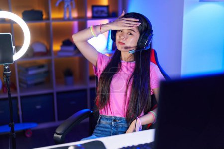 Téléchargez les photos : Young chinese woman streamer stressed using computer at gaming room - en image libre de droit