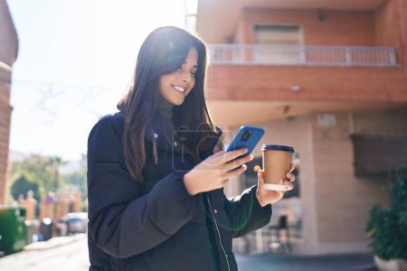 Photo for Young beautiful hispanic woman smiling confident using smartphone at street - Royalty Free Image