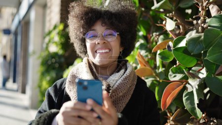 Téléchargez les photos : Young african american woman smiling confident using smartphone at street - en image libre de droit
