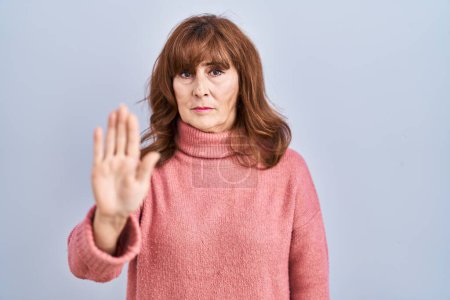 Photo for Middle age hispanic woman standing over isolated background doing stop sing with palm of the hand. warning expression with negative and serious gesture on the face. - Royalty Free Image