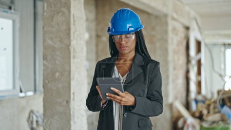 Photo for African american woman architect using touchpad thinking at construction site - Royalty Free Image