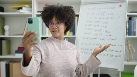 Téléchargez les photos : Jeune enseignante afro-américaine enseignant les mathématiques en ligne à l'université - en image libre de droit