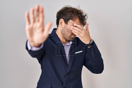 Photo for Hispanic business man wearing glasses covering eyes with hands and doing stop gesture with sad and fear expression. embarrassed and negative concept. - Royalty Free Image