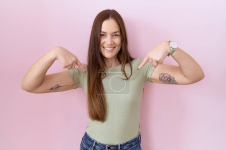 Photo for Beautiful brunette woman standing over pink background looking confident with smile on face, pointing oneself with fingers proud and happy. - Royalty Free Image