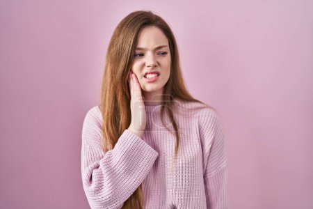 Téléchargez les photos : Young caucasian woman standing over pink background touching mouth with hand with painful expression because of toothache or dental illness on teeth. dentist - en image libre de droit