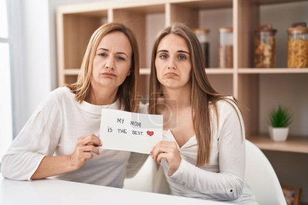 Photo for Middle age mother and young daughter holding my mom is the best banner depressed and worry for distress, crying angry and afraid. sad expression. - Royalty Free Image