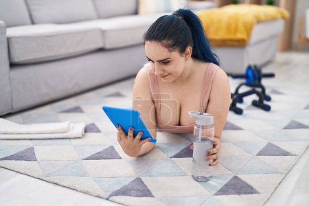 Téléchargez les photos : Young caucasian woman smiling confident using touchpad at home - en image libre de droit