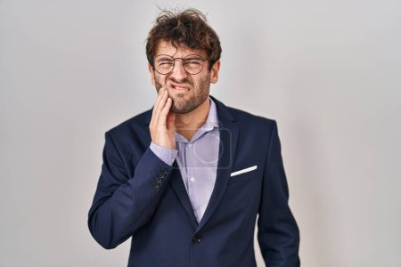 Photo for Hispanic business man wearing glasses touching mouth with hand with painful expression because of toothache or dental illness on teeth. dentist - Royalty Free Image