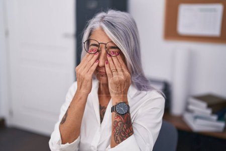 Téléchargez les photos : Femme aux cheveux gris d'âge moyen travailleuse d'affaires stressée au bureau - en image libre de droit