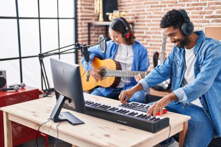 Photo for Man and woman musicians playing classical guitar and piano keyboard at music studio - Royalty Free Image