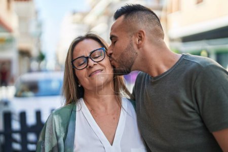 Téléchargez les photos : Homme et femme mère et fille s'embrassent dans la rue - en image libre de droit