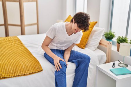 Photo for Young hispanic man suffering for knee pain at bedroom - Royalty Free Image