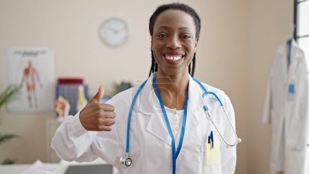 Photo for African american woman doctor smiling confident doing ok gesture at clinic - Royalty Free Image