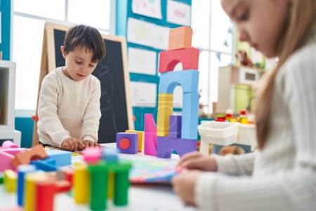 Téléchargez les photos : Adorable garçon et fille jouant avec des blocs de construction et puzzle de vocabulaire à la maternelle - en image libre de droit