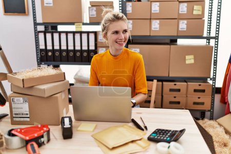 Téléchargez les photos : Jeune femme blonde ecommerce travailleur d'affaires en utilisant un ordinateur portable travaillant au bureau - en image libre de droit