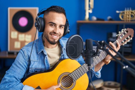 Téléchargez les photos : Jeune artiste hispanique chantant une chanson jouant de la guitare classique au studio de musique - en image libre de droit