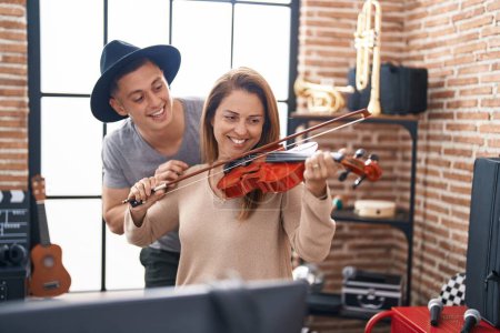 Photo for Man and woman musicians playing violin at music studio - Royalty Free Image