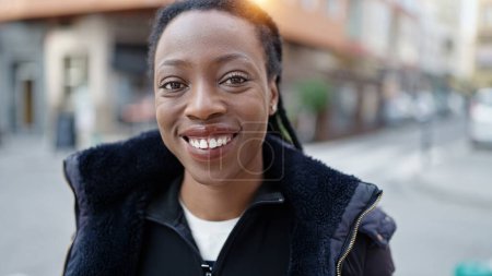 Foto de Mujer afroamericana sonriendo confiada de pie en la calle - Imagen libre de derechos
