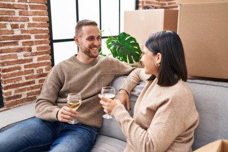 Téléchargez les photos : Homme et femme couple souriant champagne boire confiant à la nouvelle maison - en image libre de droit