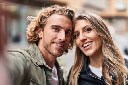 Foto de Man and woman couple smiling confident make selfie by the camera at street - Imagen libre de derechos