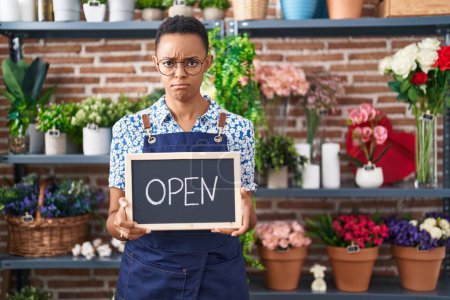 Photo for African american woman working at florist holding open sign depressed and worry for distress, crying angry and afraid. sad expression. - Royalty Free Image