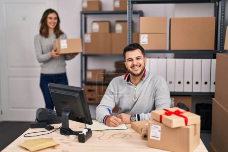Photo for Young hispanic people working at small business ecommerce looking positive and happy standing and smiling with a confident smile showing teeth - Royalty Free Image