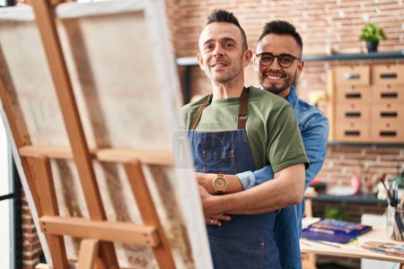 Téléchargez les photos : Deux hommes artistes se serrant dans leurs bras en regardant le studio d'art - en image libre de droit