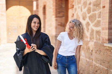 Téléchargez les photos : Deux femmes mère et fille diplômée debout ensemble à l'université du campus - en image libre de droit