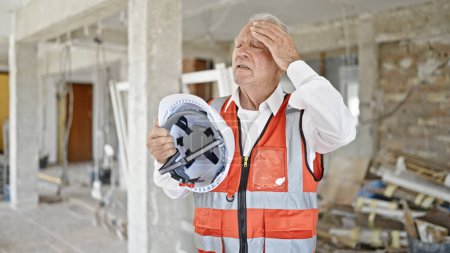 Photo for Senior grey-haired man architect using hardhat as a hand fan at construction site - Royalty Free Image