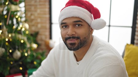 Téléchargez les photos : Homme afro-américain célébrant Noël souriant à la maison - en image libre de droit