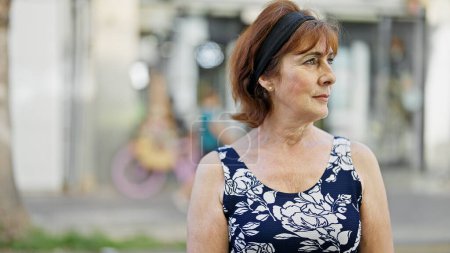 Téléchargez les photos : Middle age woman looking to the side with serious expression at street - en image libre de droit
