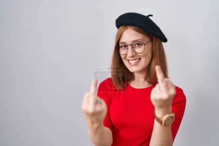 Téléchargez les photos : Young redhead woman standing wearing glasses and beret showing middle finger doing fuck you bad expression, provocation and rude attitude. screaming excited - en image libre de droit