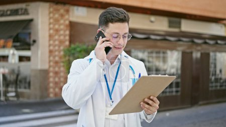 Foto de Joven médico hispano hablando en el documento de lectura de teléfonos inteligentes en la terraza de la cafetería - Imagen libre de derechos