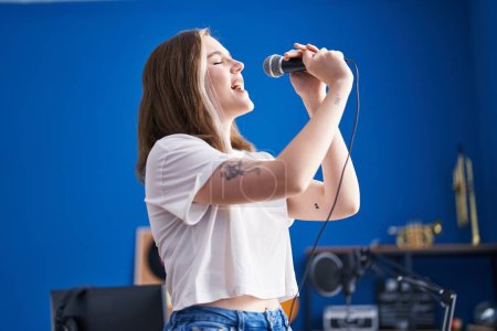 Foto de Young woman artist singing song at music studio - Imagen libre de derechos