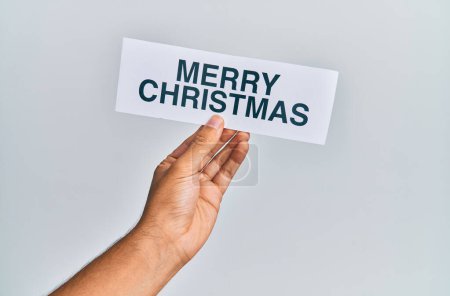 Foto de Mano de hombre caucásico sosteniendo papel con feliz mensaje de Navidad sobre fondo blanco aislado - Imagen libre de derechos
