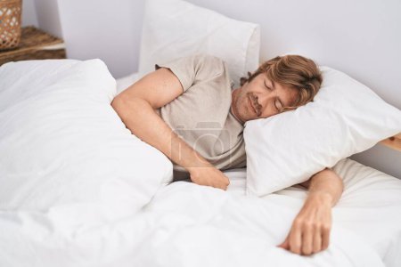 Téléchargez les photos : Jeune homme couché sur le lit dormant dans la chambre - en image libre de droit