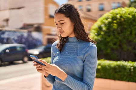 Téléchargez les photos : Jeune femme afro-américaine utilisant un smartphone dans la rue - en image libre de droit