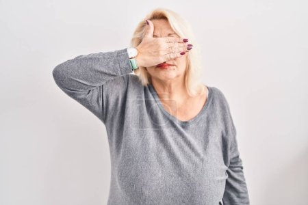 Photo for Middle age caucasian woman standing over white background covering eyes with hand, looking serious and sad. sightless, hiding and rejection concept - Royalty Free Image