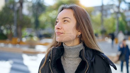 Téléchargez les photos : Jeune femme caucasienne souriant confiant regardant vers le ciel à la rue - en image libre de droit