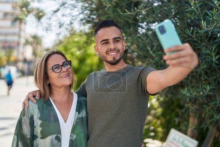 Foto de Hombre y mujer madre e hija hacen selfie por teléfono inteligente en el parque - Imagen libre de derechos