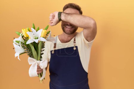 Photo for Middle age man with beard florist shop holding flowers smiling cheerful playing peek a boo with hands showing face. surprised and exited - Royalty Free Image
