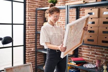 Téléchargez les photos : Jeune femme blonde souriant confiant regarder dessiner au studio d'art - en image libre de droit