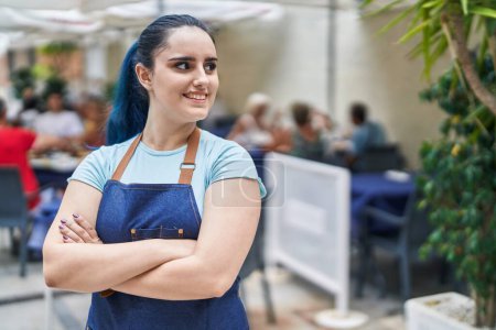 Téléchargez les photos : Jeune femme caucasienne serveuse souriante confiante debout avec les bras croisés geste à la terrasse du café - en image libre de droit